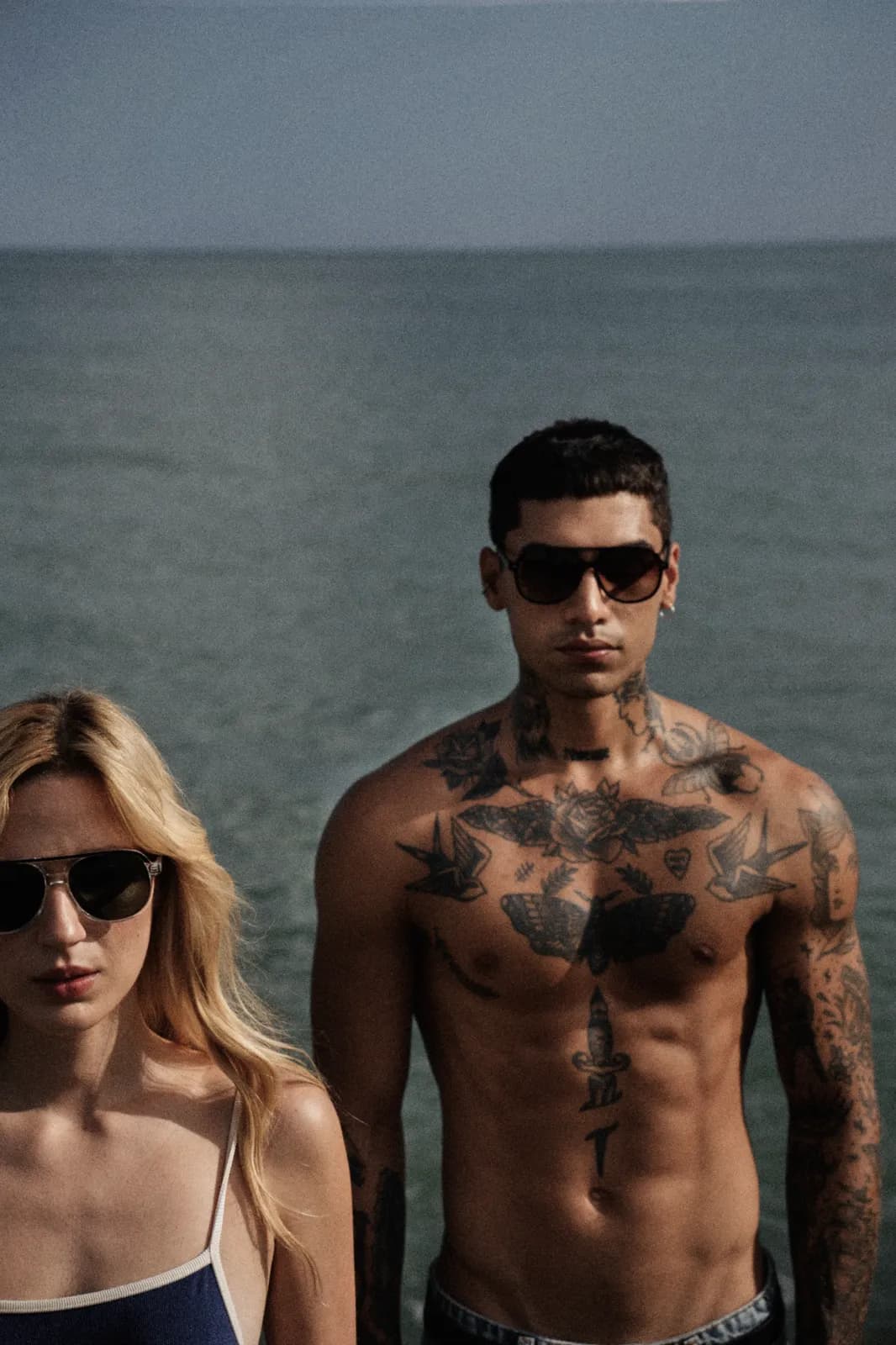 Casal usando óculos solares Ziren à beira-mar