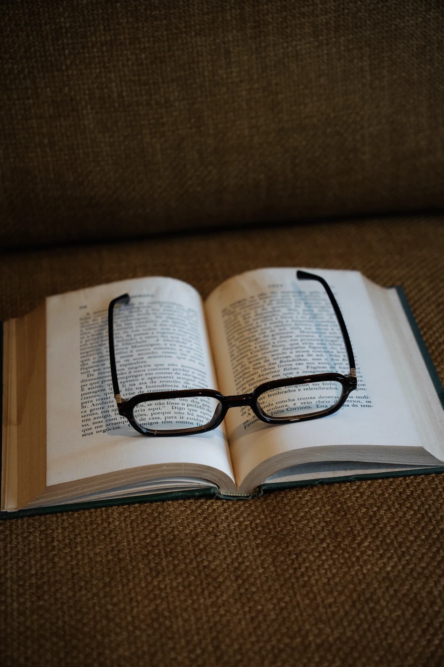 Óculos da Ziren repousando sobre um livro aberto