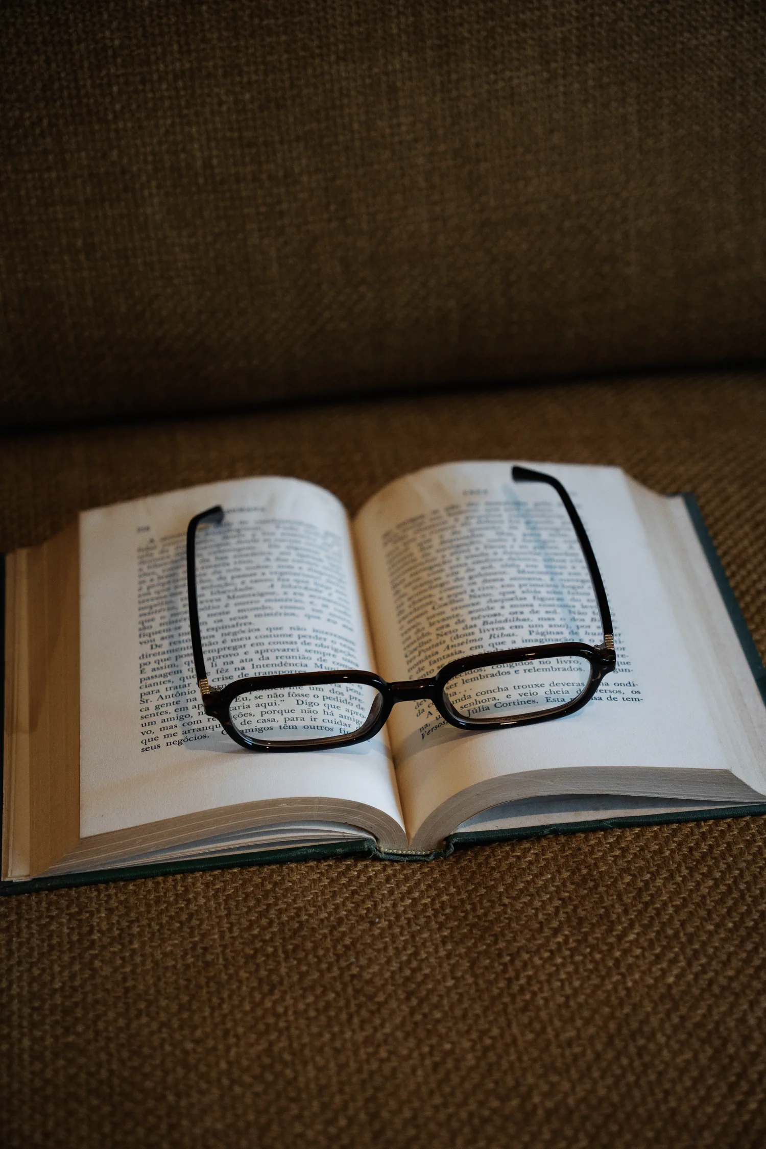 Óculos da Ziren repousando sobre um livro aberto